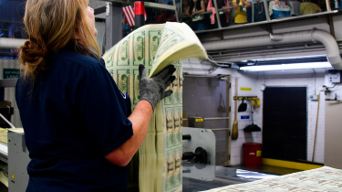 US mint worker holding sheets of $20 bills  AFP via Getty Images